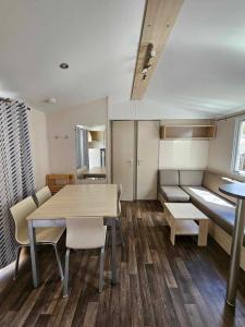 a room with a table and chairs and a couch at camping de l'or bleu in Barrême