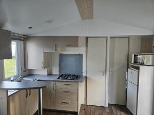 a small kitchen with a stove and a refrigerator at camping de l'or bleu in Barrême +7 photos