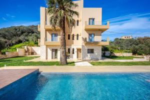 a villa with a swimming pool in front of a house at Chrisselen Stalos in Chania
