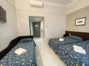 a hotel room with two beds and a mirror at Club Hotel in Milan