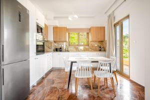 a kitchen with white cabinets and a table and chairs at Chrisselen Stalos in Chania