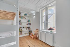 a room with a book shelf and a window at Les Volets Bleus de Trouville - Centre - Plage in Trouville-sur-Mer