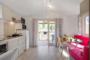 a kitchen with a red couch and a table in a room at Camping Groene Eiland in Appeltern +14 photos