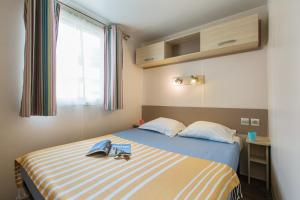 a bedroom with a bed with a book on it at Camping Groene Eiland in Appeltern
