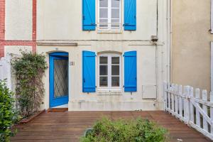 a white building with blue doors and windows at Les Volets Bleus de Trouville - Centre - Plage in Trouville-sur-Mer
