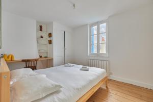 a white bed in a room with a window at Les Volets Bleus de Trouville - Centre - Plage in Trouville-sur-Mer