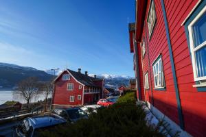 a red house and cars parked next to a building at Voss Folkehøgskule in Vossevangen