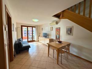 a living room with a table and a kitchen at Stella Marina in Grado