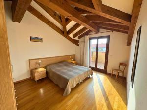 a bedroom with a bed in a room with wooden floors at Stella Marina in Grado