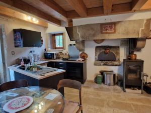 a kitchen with a table and a kitchen with an oven at La Cabiole in Claudon