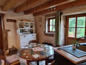 a living room with a table and a kitchen at La Cabiole in Claudon +30 photos
