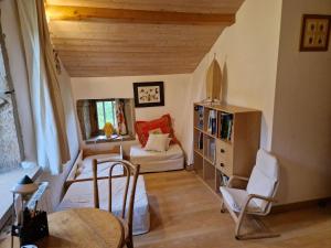 a room with a bed and a table and chairs at La Cabiole in Claudon