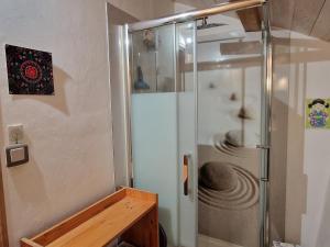 a shower with a glass door in a bathroom at La Cabiole in Claudon