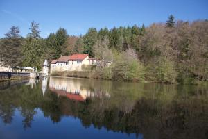 a view of a river with a house and trees at La Cabiole in Claudon