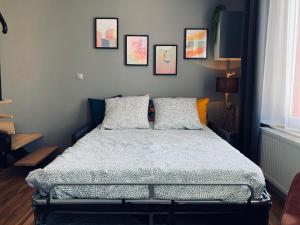 a bedroom with a bed with four pictures on the wall at La bulle des Viennes MAISON CLIMATISEE - CHAMPAGNE in Sainte-Savine