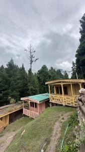 a couple of houses on top of a field at Fairy meadows BroadView Hotel in Tato