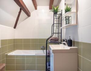 a bathroom with a bath tub and a sink at Duplex 80m2 AC I Balcon Parking I Route des Vins in Marlenheim