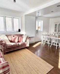 a living room with a couch and a table and chairs at La Villa Rustique-2 in Notre-Dame-du-Lac