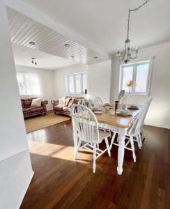 a dining room with a table and white chairs at La Villa Rustique-2 in Notre-Dame-du-Lac