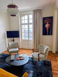 a living room with two chairs and a table at Ker Marlyne - Proche du Port in Dinard +9 photos