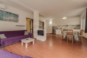 a living room with a purple couch and a table at Azzurro Mare a Seccheto - Goelba in Seccheto