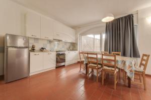 a kitchen with a table and chairs and a refrigerator at Azzurro Mare a Seccheto - Goelba in Seccheto +9 photos
