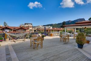 a patio with wooden tables and chairs and buildings at NATURELLA APART HOTEL in Kemer