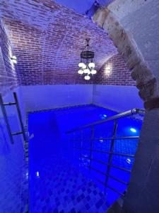 a swimming pool with a blue lighting in a room at Hasan Bey Konakları in Avanos