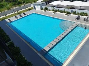 an overhead view of a large swimming pool with lounge chairs at Halimah Guesthouse in Putatan