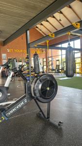 a gym with a fan and two boxing bags at Elara in Sandton