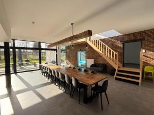 a dining room with a long wooden table and chairs at Moulin de Baillonville in Baillonville