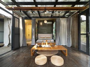 a bedroom with a bed and a table at Limu Mountain Forest Park in Hainan