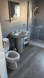 a bathroom with a toilet and a sink and a shower at Argyll Hotel in Ullapool +51 photos
