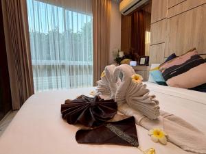 a towel animal sitting on top of a bed at Deco Harmony Pattaya 1 in North Pattaya