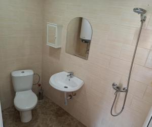 a bathroom with a toilet and a sink and a shower at Millies Place in Elkhovo