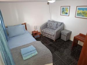 a small bedroom with a bed and a chair at Millies Place in Elkhovo
