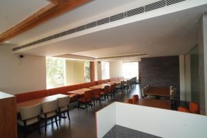 a dining room with wooden tables and chairs at Hotel Navas Inn- Pure Veg, Kolhapur in Kolhapur