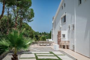 a courtyard of a white building with a table and chairs at J&K Villa in Kalithies +64 photos