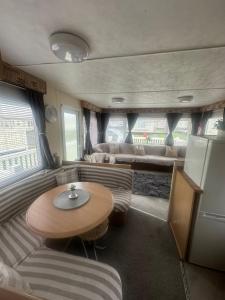 a living room with a table and a couch in an rv at Sandylands caravan park in Stevenston