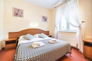 a bedroom with a bed with two towels on it at IK Apartamenty in Rzeszów