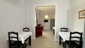 a dining room with two tables and a red couch at Thomar House in Tomar