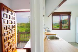 a kitchen with a sink and a balcony at La balcon de Sanfer in Santillana del Mar