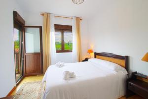 a bedroom with a white bed and a window at La balcon de Sanfer in Santillana del Mar