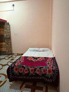 a bed in a room with a blanket on it at New Giri Homestay in Nichlaul