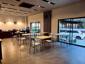 a restaurant with tables and chairs and a car outside at HF Ville in Ban Tha Phet Noi
