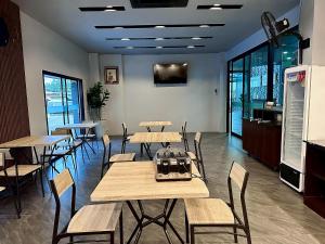 a restaurant with tables and chairs in a room at HF Ville in Ban Tha Phet Noi