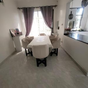 a dining room with a white table and chairs at Mary homestays in Dar es Salaam