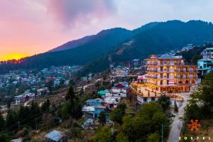 a view of a town in the mountains at sunset at Zostel Dharamkot, Bhagsu in McLeod Ganj +33 photos