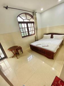 a bedroom with a bed and a table and a window at LotusHotel 2 in Ho Chi Minh City +5 photos