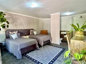 a bedroom with two beds and a chair and a table at SPAat343 in Roodeplaat